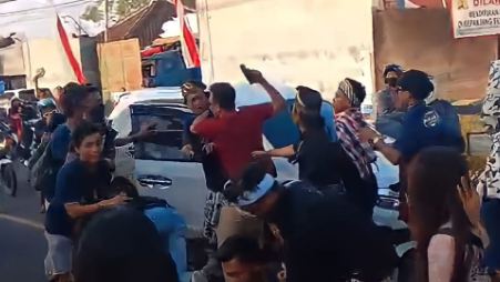 seorang mengacungkan pistol ke peserta karnaval