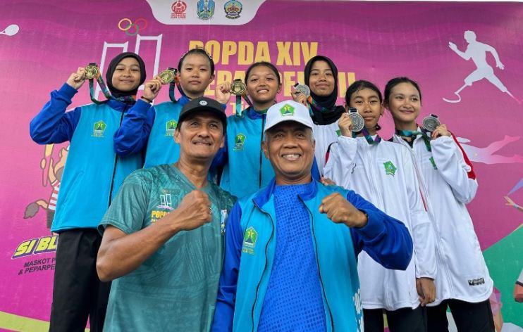Foto atlet balap sepeda dari Kota Madiun dan Kabupaten Bayuwangi yang sedang berpose dengan medali emas yang mereka raih.