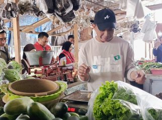 Aiptu Prasetya Wicaksono dari Satgas Pangan Polresta Banyuwangi menanyakan harga cabai dan kebutuhan pokok di lapak bumbu dapur Pasar Banyuwangi saat Ramadan 2026