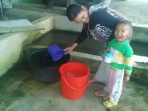 Salah seorang ibu rumahtangga mengambil air hujan Foto : Roy Prawira Pandia