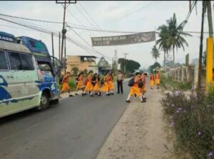 Personil Polsek Tigabinanga Atur Arus Lalin Serta Bantu Pelajar Menyebarang Jalan Raya