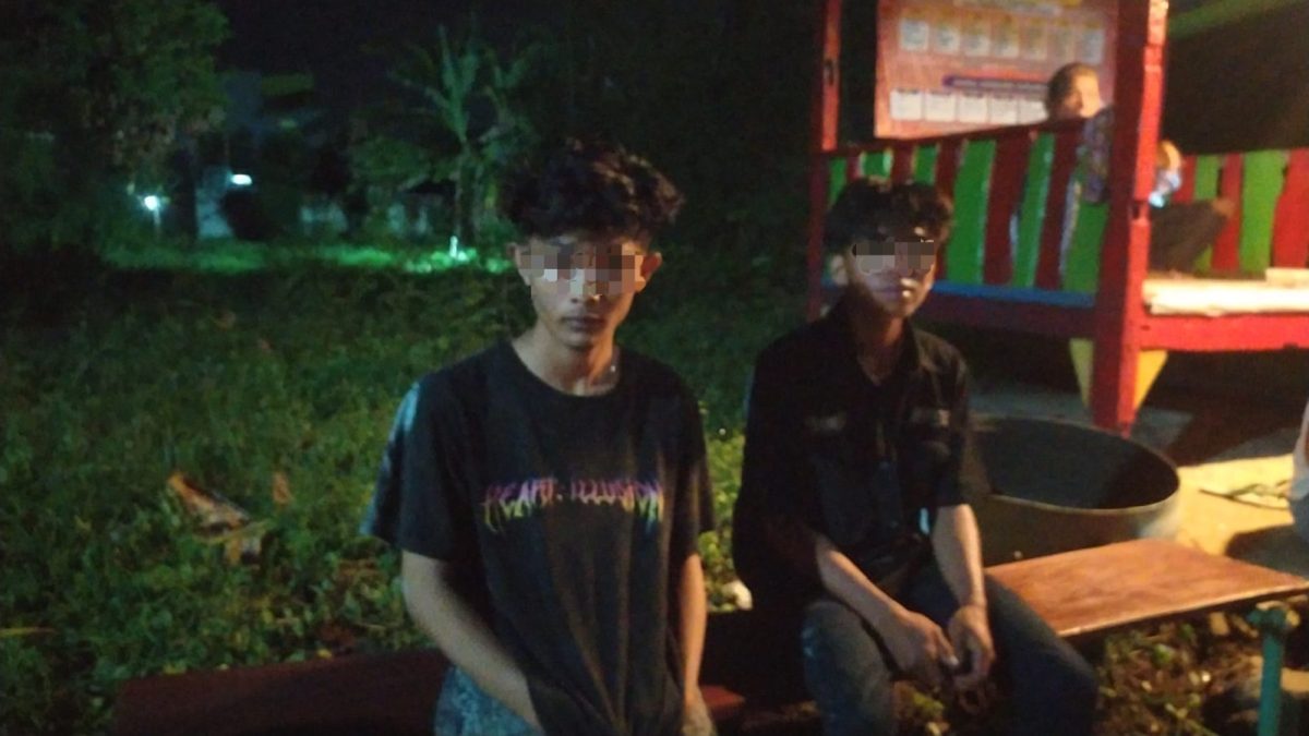 Warga Singotrunan mengamankan dua pemuda yang berperilaku mencurigakan di Banyuwangi pada malam hari.