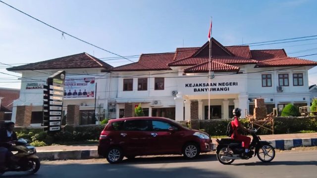Foto bagian depan Gedung Kejaksaan Negeri Banyuwangi dengan papan nama resmi dan lambang kejaksaan di halaman depan.