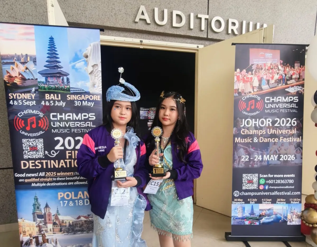 Cherie Callista Wangsa dan Vivianne Vernetta Wangsa berpose sambil mengangkat trofi usai meraih penghargaan pada Champs Universal Music Festival 2026 di Johor, Malaysia.