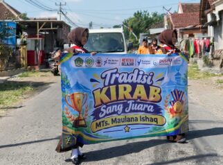 Siswa MTs Maulana Ishaq membawa piala saat Kirab Sang Juara di Desa Benelanlor Banyuwangi