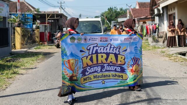 Siswa MTs Maulana Ishaq membawa piala saat Kirab Sang Juara di Desa Benelanlor Banyuwangi